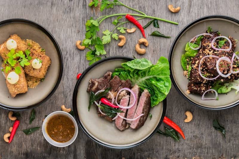 Ranked third: overhead food shot of sliced beef and salad on a stone plate